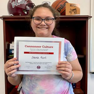 Grade 8 Cannoneer Culture "Be Present" Student of the Month for October 2022 holding award certificate and smiling at camera.