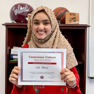 Grade 8 Cannoneer Culture "Be Positive" Student of the Month for October 2022 holding award certificate and smiling at camera.