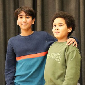 The spelling bee champion and first runner up pose for a photo on the stage after competition.