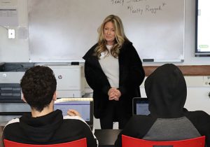 Local entrepreneur talks to students seated at front of classroom.