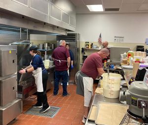 Baseball and softball coaches and assistants gather in the kitchen at Watervliet Junior Senior High School to make pancake breakfasts to serve at a fundraiser in March.