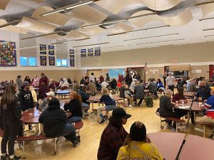 Students, families and community members seated at tables in the cafeteria at Watervliet Junior Senior High School for a pancake breakfast fundraiser.