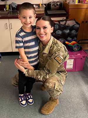 Kneeling aunt hugs nephew, kindergarten student at WES. Both are smiling.