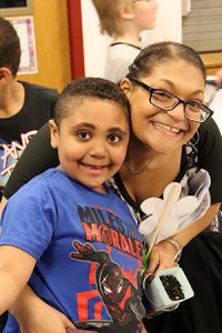 A special person hugs a student as they pose smiling for a photo during Special Persons Night at Watervliet Elementary School. 