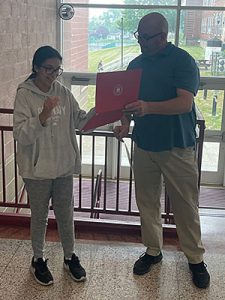 High school science department chairperson presents the Rensselaer Medal to student