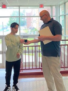 High school science department chairperson presents the Bausch and Lomb Honorary Science Award to student 