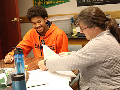 A high school senior smiles as he speaks with as admissions counselor from HVCC. 