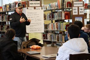 Local trades union representative speaks to students seated at desks in the library