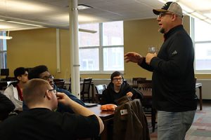 Local trades union representative speaks to students seated at desks in the library