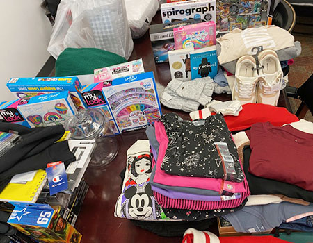 a collection of clothing, toys and books on a table