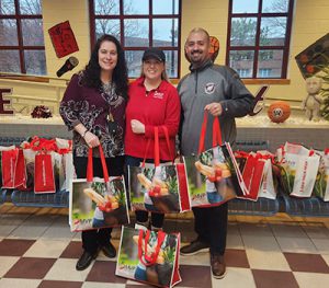 MVP representative presents bags of donated clothing to district administrators