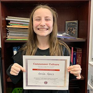 Be Positive grade 7 student of the month holds award certificate and smiles at camera