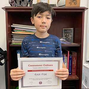 Be Present grade 6 student of the month holds award certificate and smiles at camera