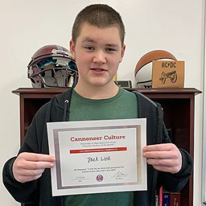 Be Present grade 8 student of the month holds award certificate and smiles at camera