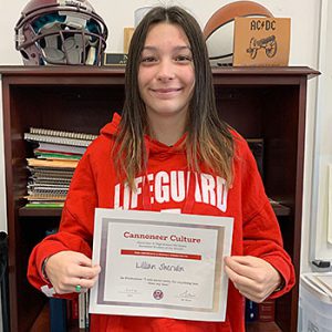 Be Productive grade 7 student of the month holds award certificate and smiles at camera