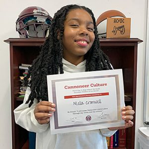 Be Proud grade 7 student of the month holds award certificate and smiles at camera