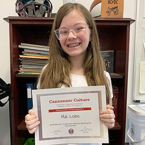 Be Productive grade 6 student of the month holds award certificate and smiles at camera