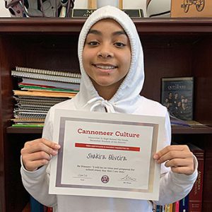 Be Present grade 7 student of the month holds award certificate and smiles at camera