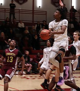 Watervliet basketball player jumps and holds the ball in midair while approaching the basket