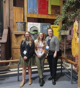 Watervliet UPK educators and director stand in front of a Sesame Street exhibit at the New York State Museum