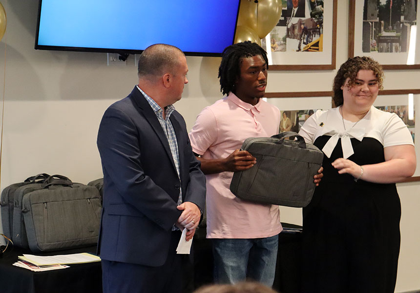A graduating senior from Watervliet High School accepts a new laptop from the Watervliet Housing Authority