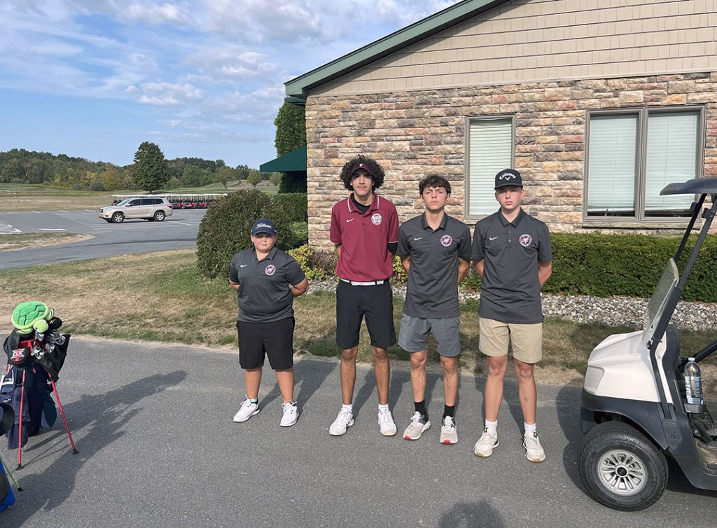 Four members of the golf team stand together in front of clubhouse