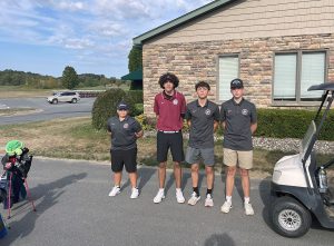 Four members of the golf team stand together in front of clubhouse
