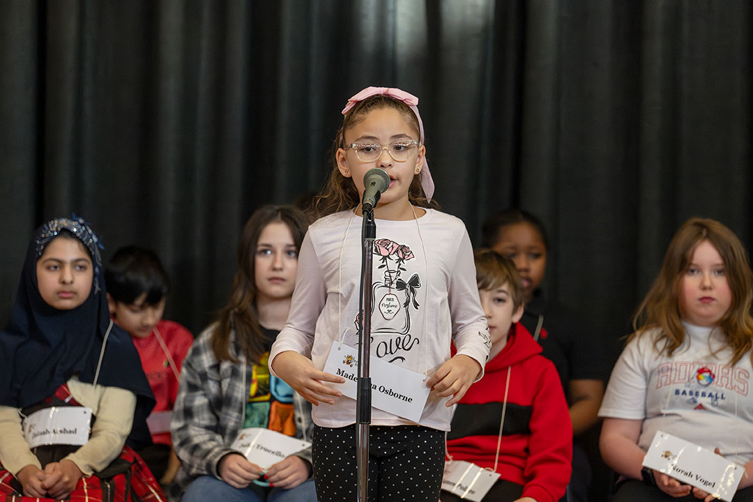 A speller speaks into the microphone during the competition