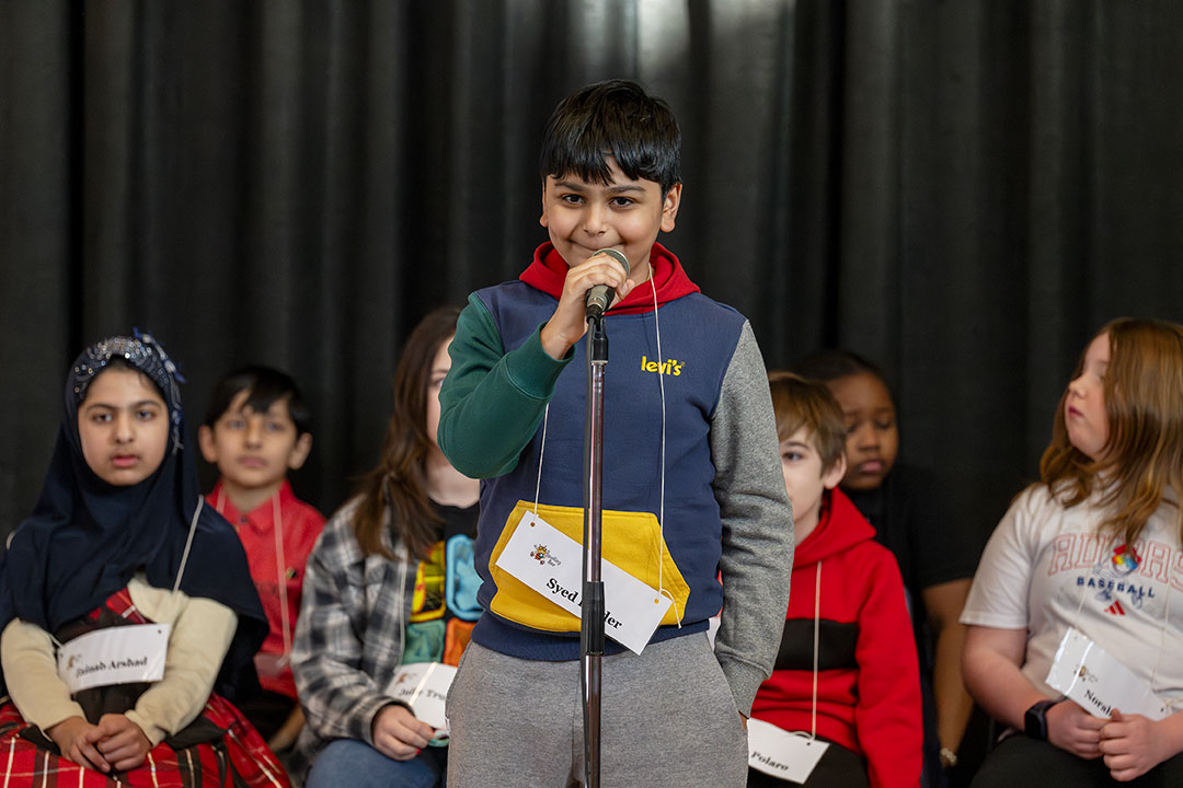 A speller speaks into the microphone during the competition
