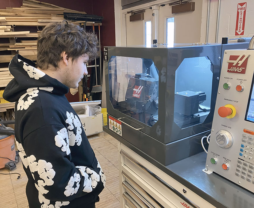 A student observes manufacturing equipment in action