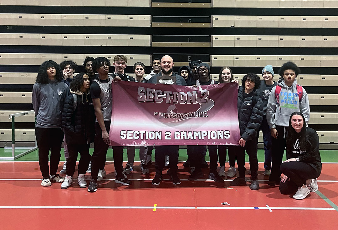 Track team and coaches hold sectional championship banner