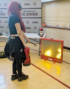 A student handles a fire extinguisher at the Career Fair