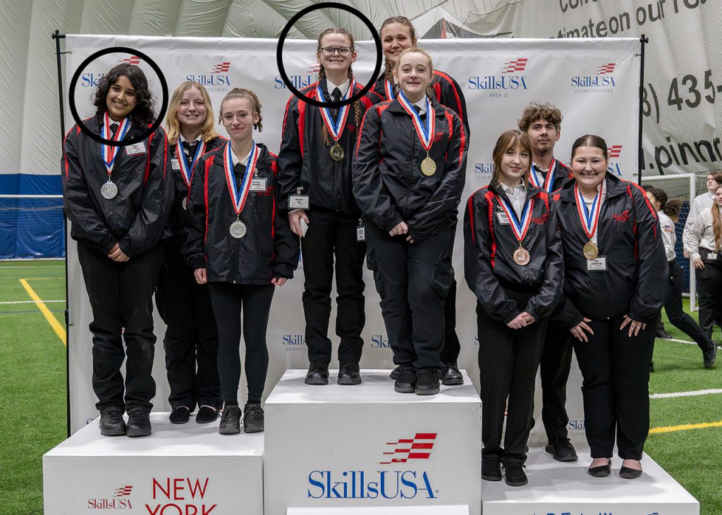 Two Watervliet students stand on podium with team members after finishing first and second place in the regional Skills USA contest. 