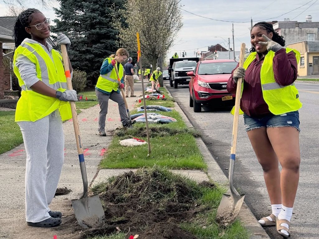 Two character education students stand with two advisors with shovels in hand and smiles are the faces