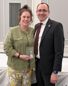 Watervliet administrator holds an award while standing next to the superintendent