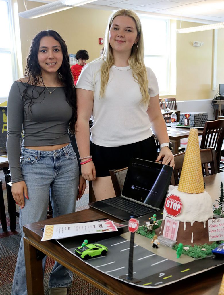 Two students stand near their collaborative city project display