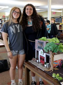 Two students stand near their collaborative city project display