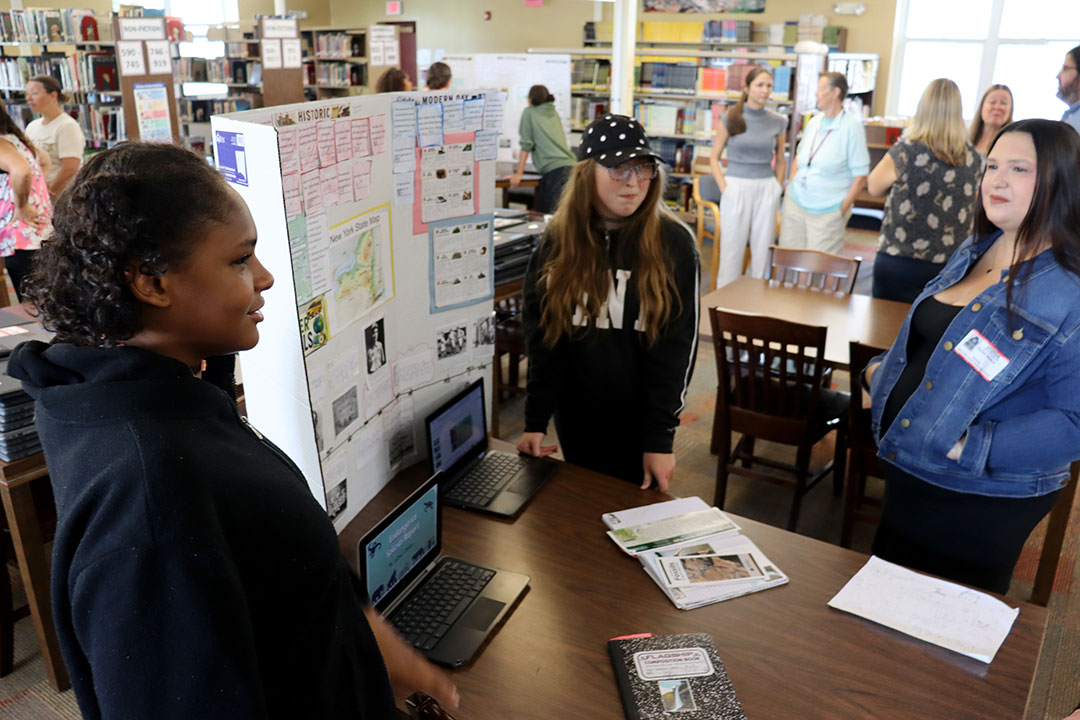 Students present their final projects on the Summer Travel Program to administrators, teachers and invited guests